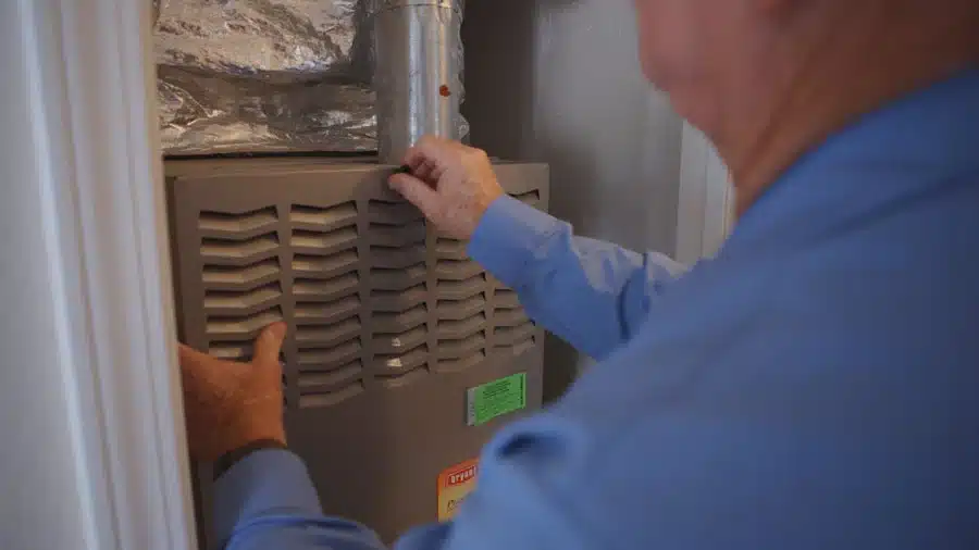 Central Elite technician inspecting and repairing a furnace in Fresno CA