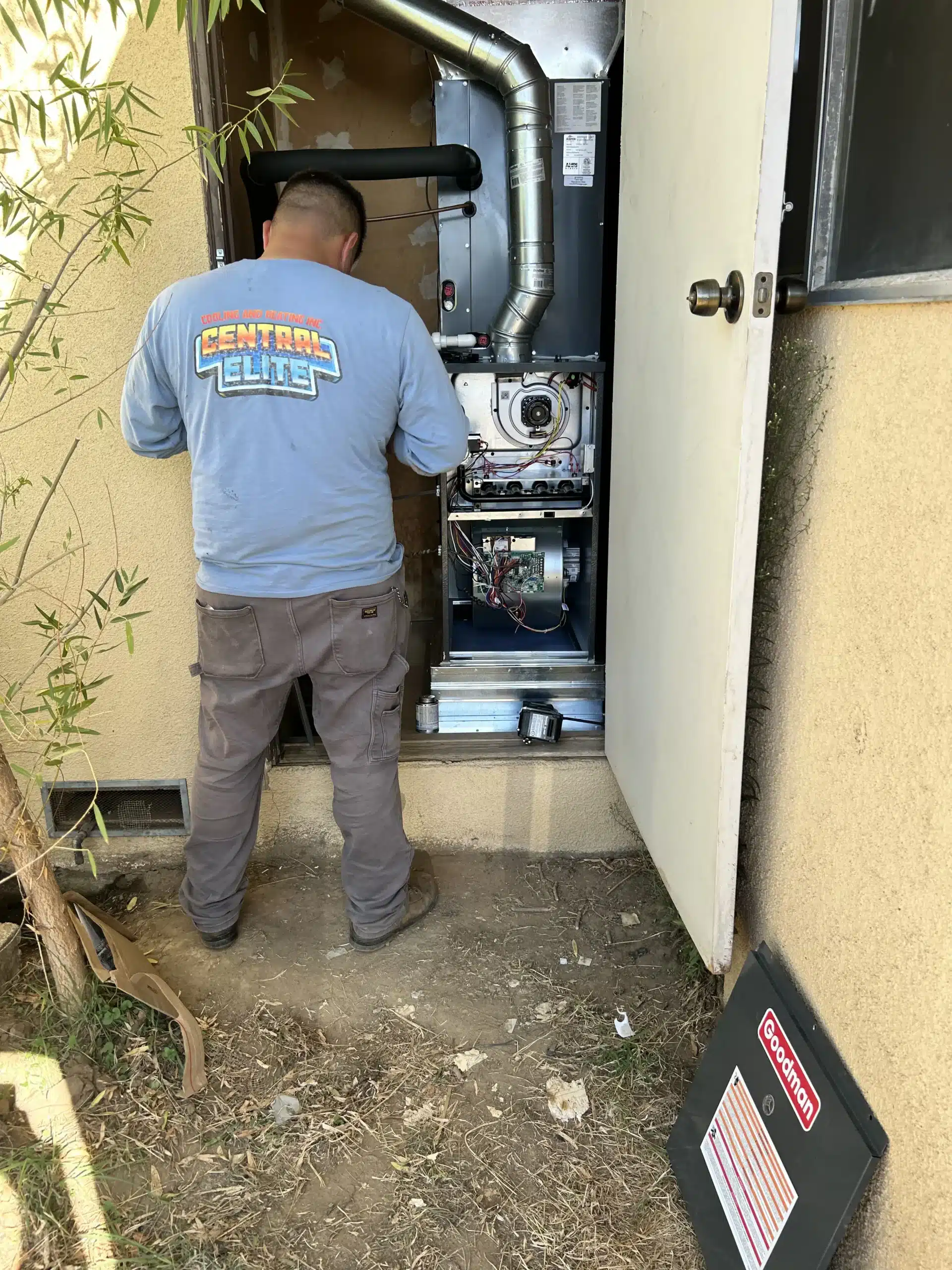 Central Elite HVAC technician servicing a system in Selma California
