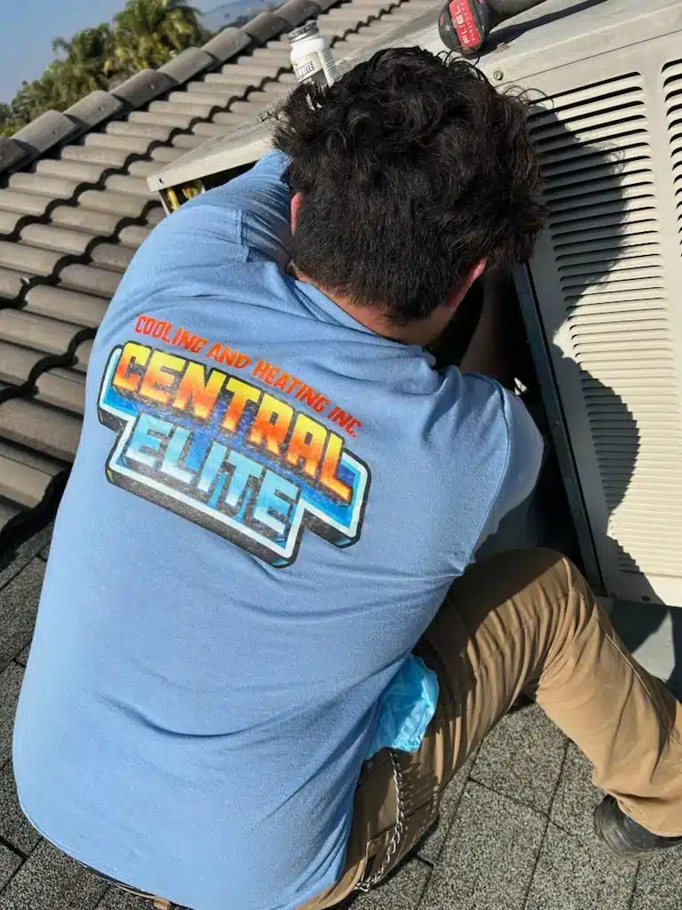 Central Elite technician maintaining a rooftop AC unit in Fresno