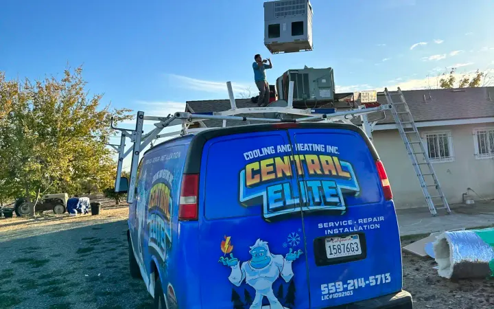 Crane lifting a new rooftop AC unit onto a Central Valley home during a Central Elite installation