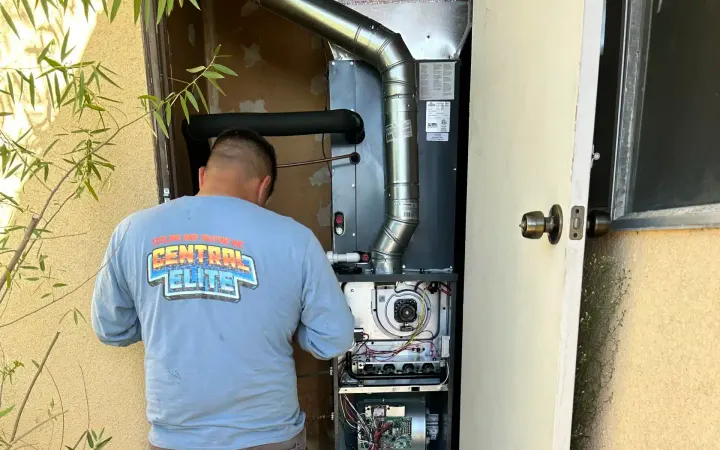 Central Elite technician servicing a furnace at a Fresno home