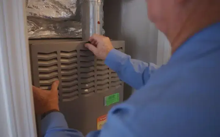 Technician performing an annual furnace inspection as part of a Central Elite maintenance plan